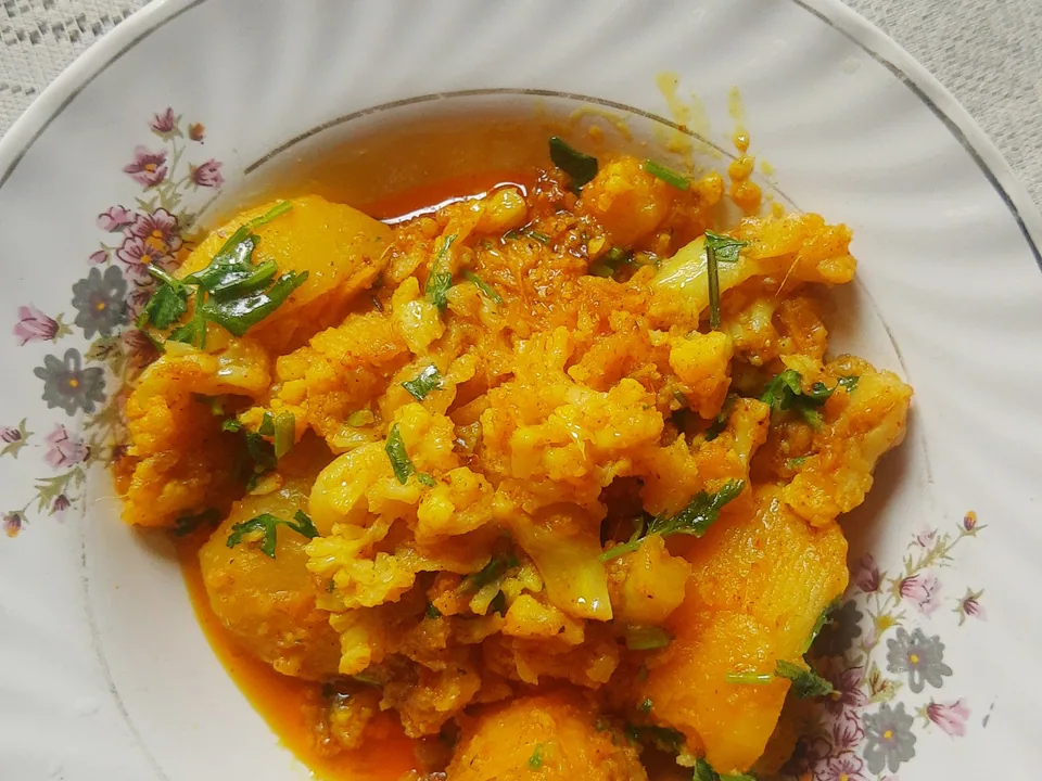 Dry aloo gobi with golden potato chunks, browned cauliflower florets, tomato masala, and cilantro