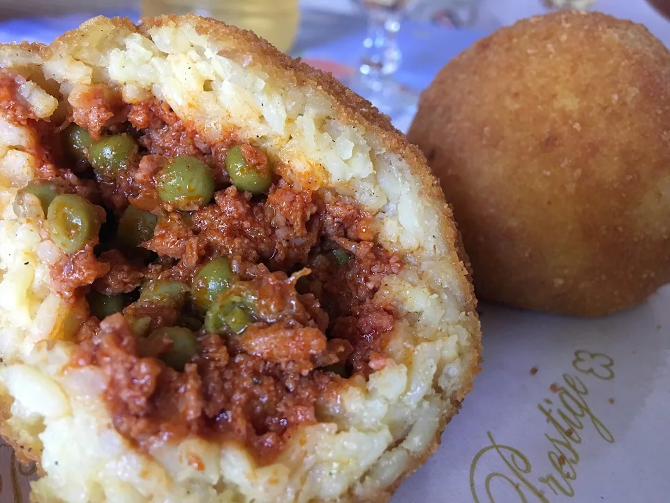 Crisp golden arancini with ragù, peas and melted mozzarella inside