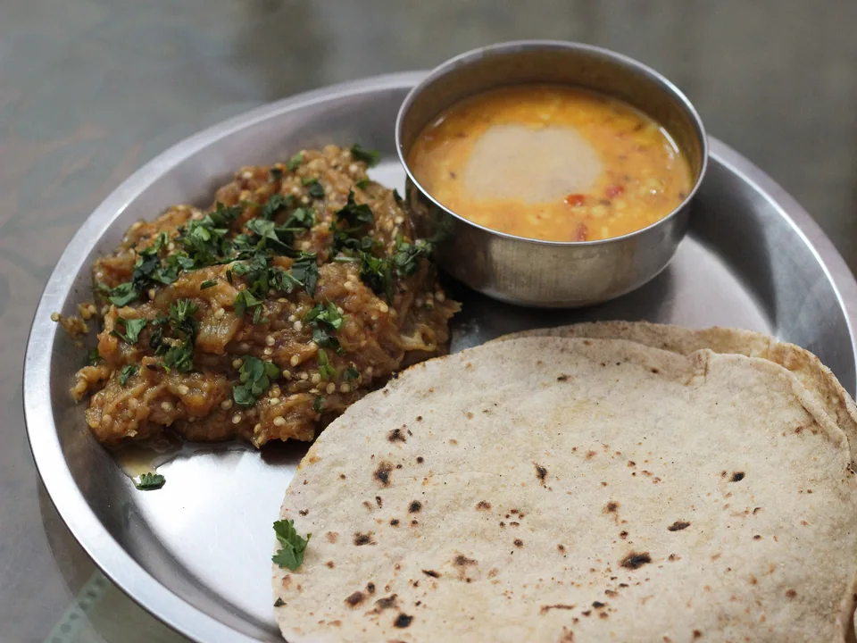Smoky baingan bharta with rustic eggplant strands, onion, tomato, green chile, and cilantro