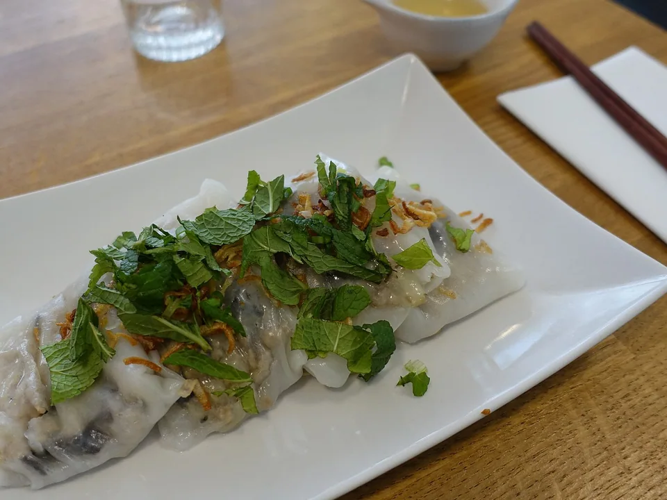 White pork-and-mushroom rice rolls topped with fried shallots and served with Vietnamese steamed pork sausage