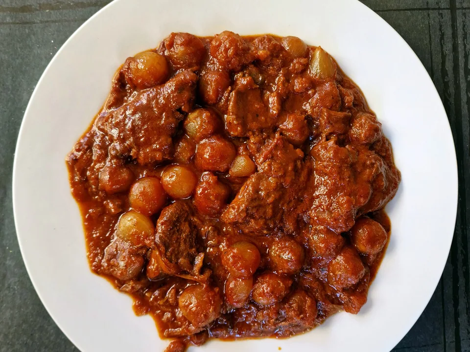 Greek beef stifado with pearl onions in glossy red-wine tomato sauce