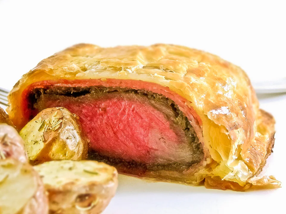 Sliced Beef Wellington with rosy beef, mushroom layer and golden puff pastry