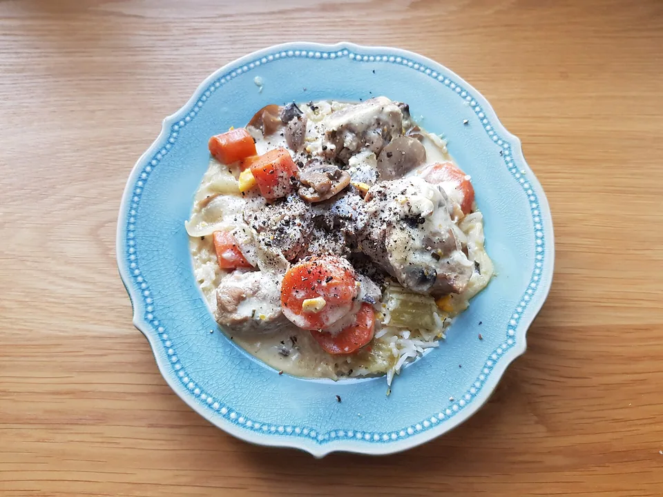 Veal, carrots and mushrooms in pale cream sauce with rice and black pepper