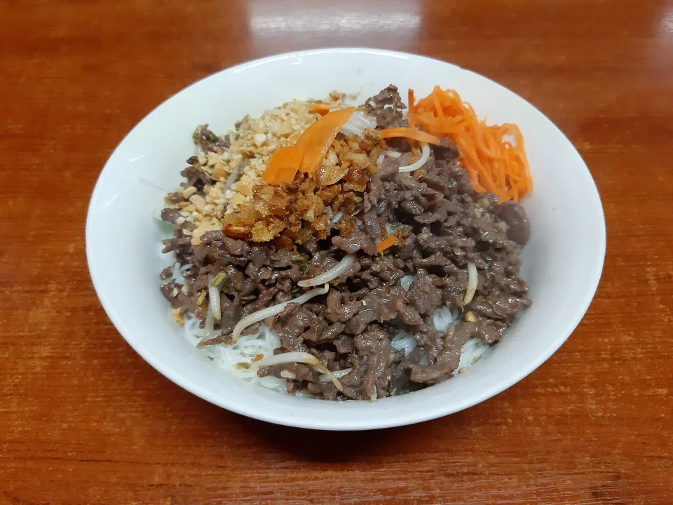 Rice vermicelli topped with stir-fried beef, bean sprouts, pickled carrot, peanuts and fried shallots