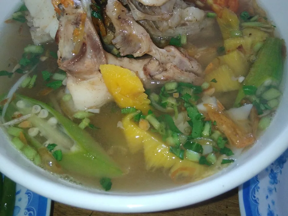 Sweet-sour fish soup with pineapple, tomatoes, okra and herbs