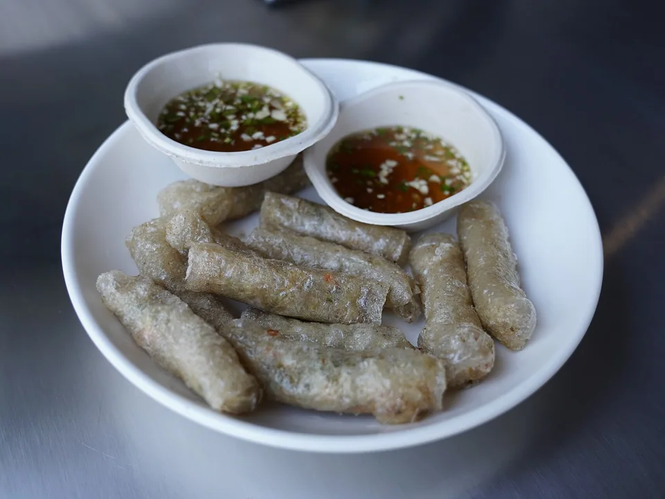 Golden Vietnamese fried rice-paper rolls with lettuce, herbs, and dipping sauce