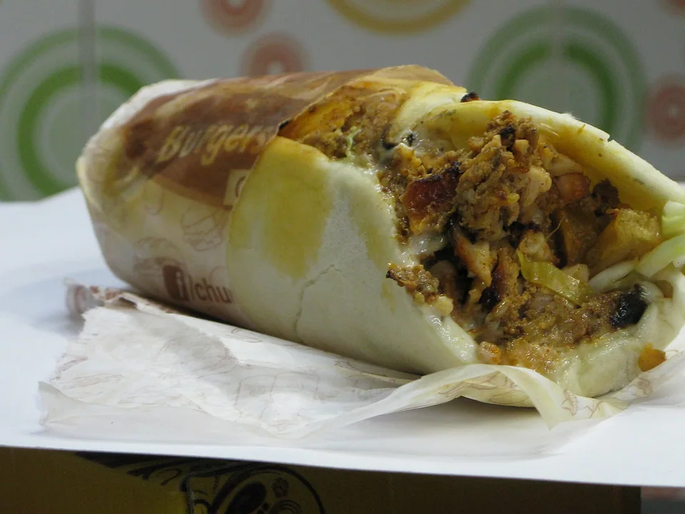 Chicken shawarma slices with browned spiced edges in a warm pita wrap