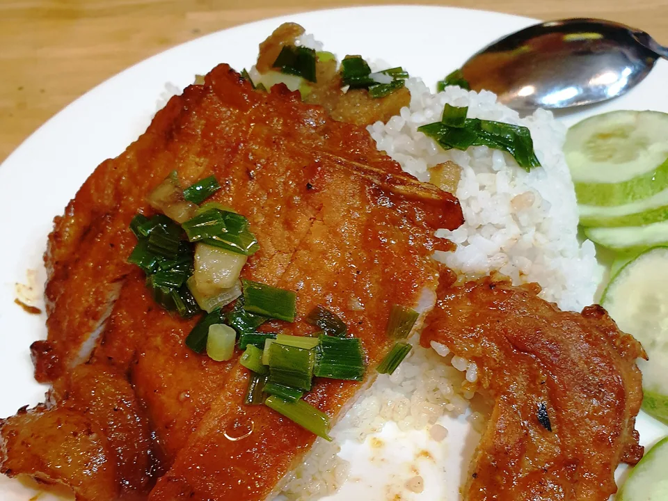 Broken rice with a grilled lemongrass pork chop, scallion oil, cucumber, tomato, and pickles