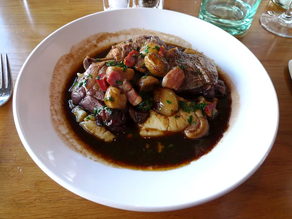 Chicken in red-wine sauce with bacon, mushrooms and pearl onions over mashed potatoes