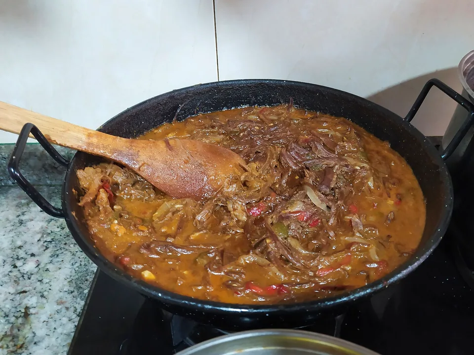 Cuban ropa vieja shredded beef with peppers, tomato, rice and black beans