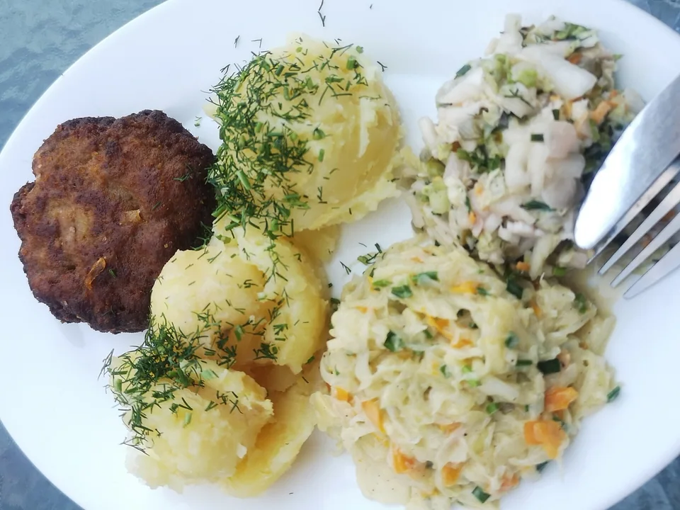 Golden-brown German Frikadellen meat patties with mustard and potato salad