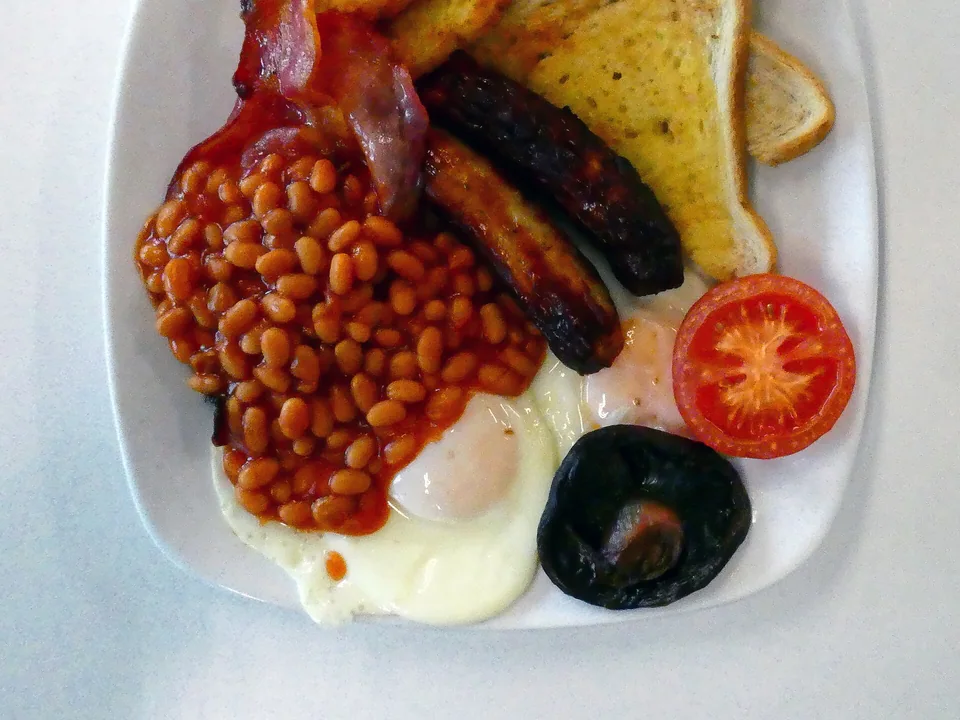 Full English breakfast with sausage, bacon, egg, black pudding, mushrooms, tomato, beans and fried bread