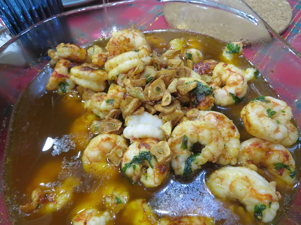 Pink prawns sizzling in golden garlic-chilli olive oil with parsley