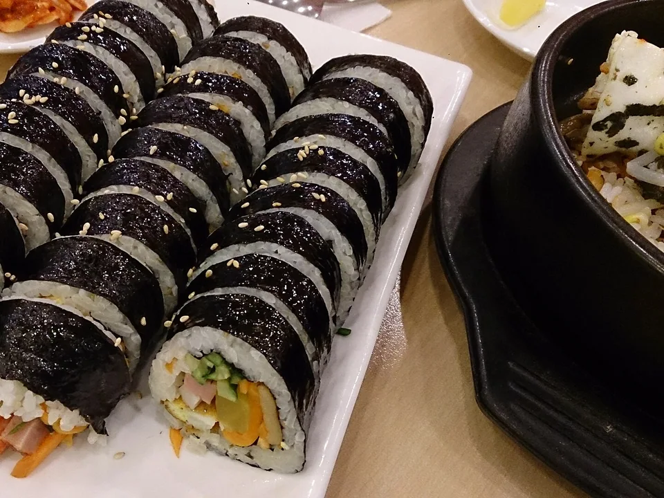 Sliced assorted gimbap with egg, ham, crab, carrot, cucumber, and yellow radish