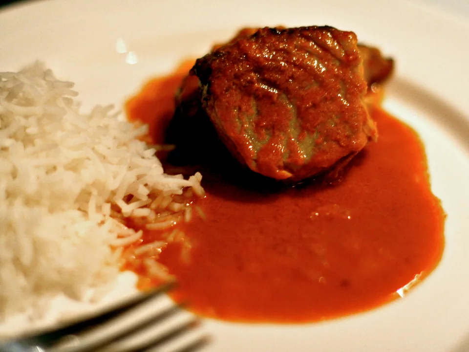 Goan fish curry with intact white fish pieces in smooth red-orange coconut sauce