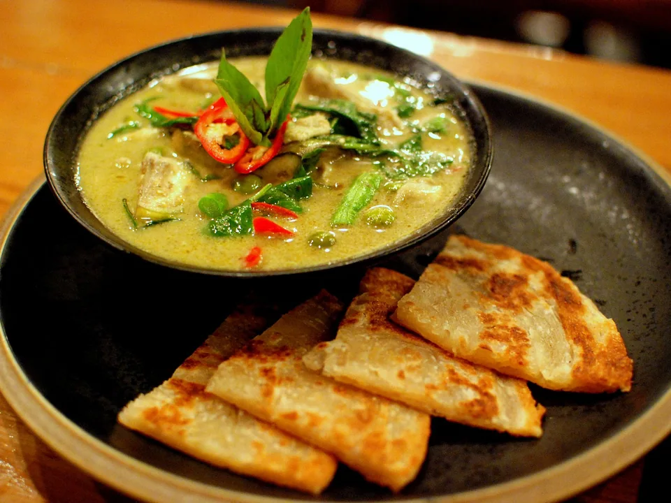 Thai green chicken curry with eggplant, bamboo shoots, basil, red chile, and roti
