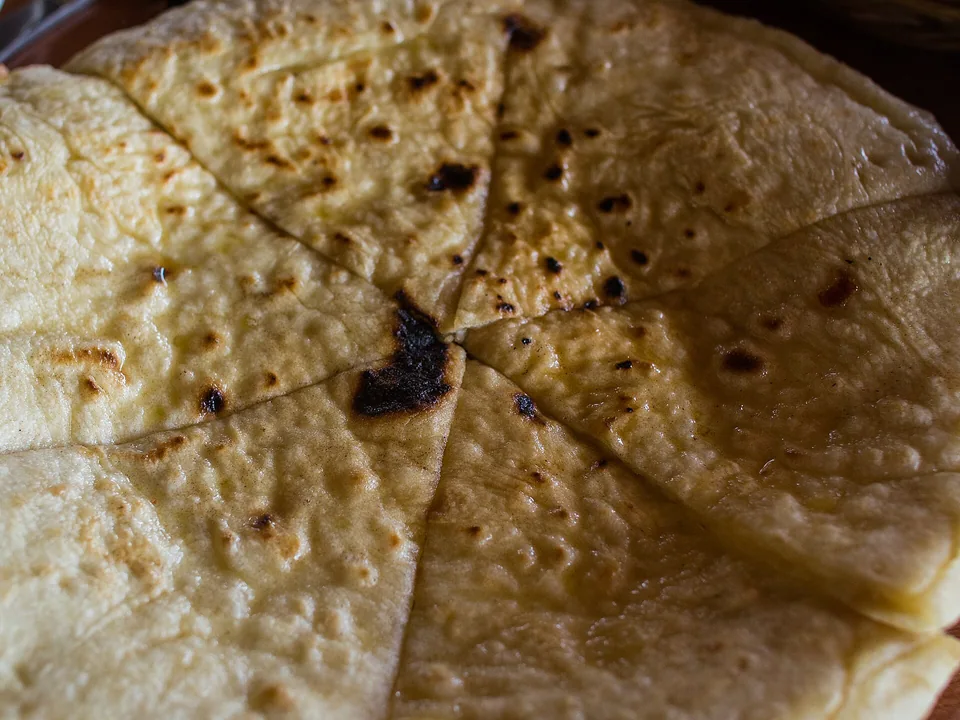 Round Imeretian khachapuri cheese bread baked golden and brushed with butter