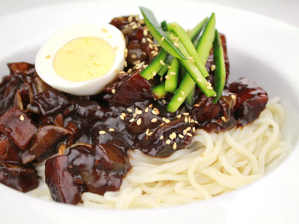 Fresh noodles under glossy black-bean pork and vegetable sauce with cucumber