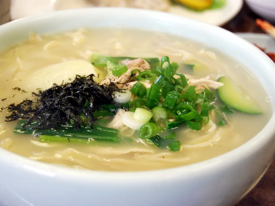 Hand-cut chicken noodle soup with shredded thigh, potato, zucchini, onion, and scallions