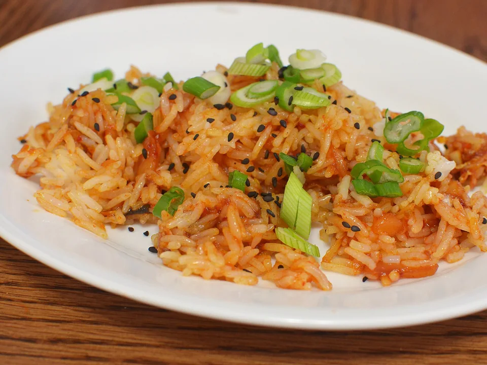 Caramelized red kimchi fried rice with separated grains and scallions