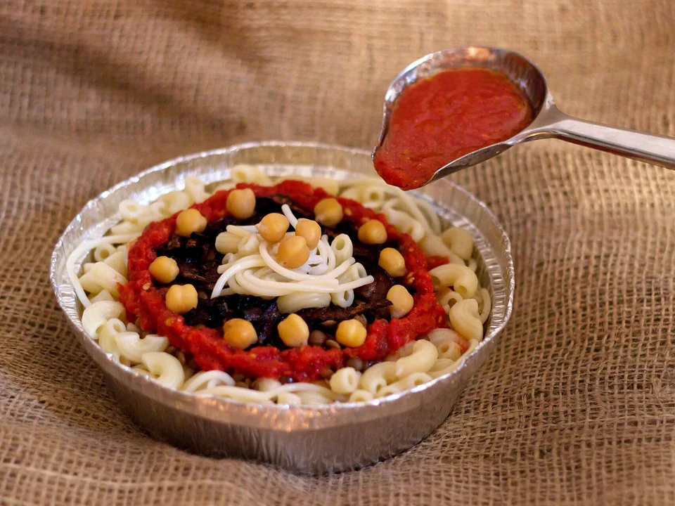 Egyptian koshari layers of rice, lentils, pasta, chickpeas, tomato sauce and crispy onions