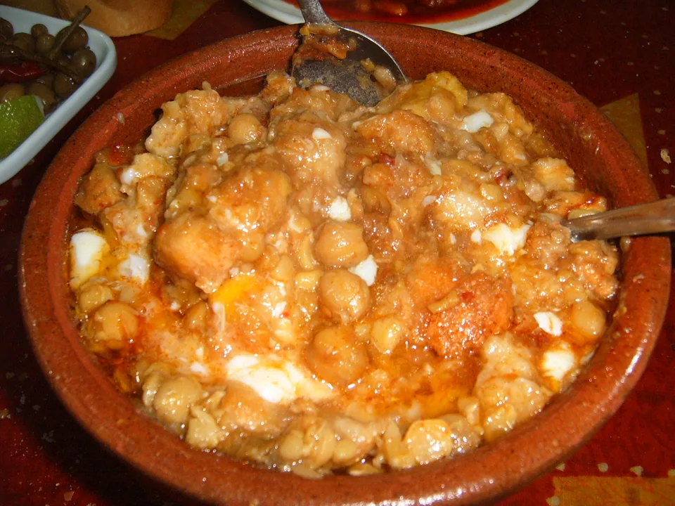 Tunisian lablabi chickpea soup poured over torn bread with lemon, olive oil and harissa