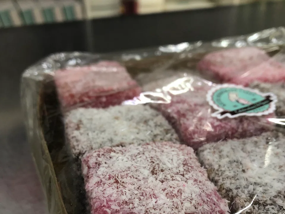 Australian lamington sponge squares coated in chocolate icing and coconut with raspberry jam filling