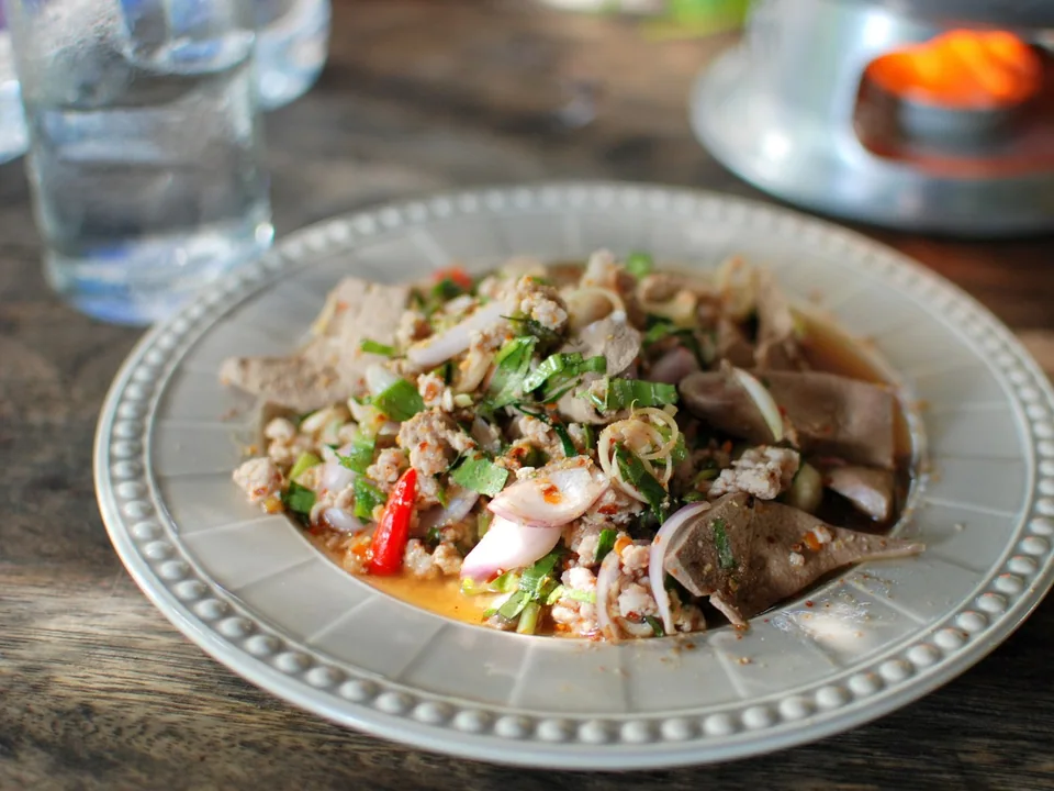 Larb Moo with cooked ground pork, toasted rice, shallot, mint, cilantro, lime, and chile