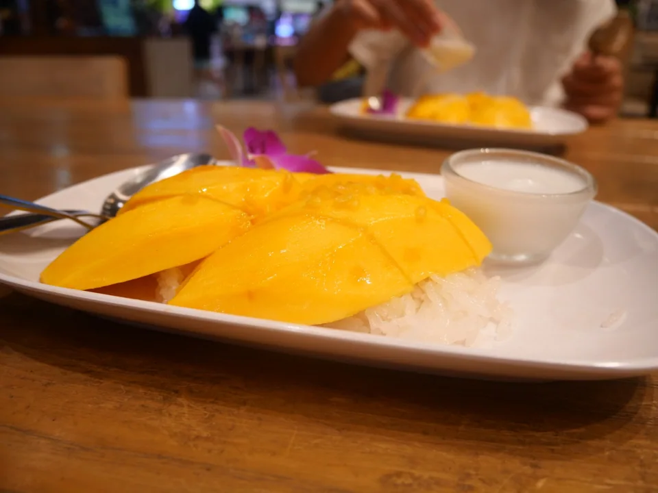 Classic white mango sticky rice with ripe yellow mango, coconut topping, and crisp mung beans