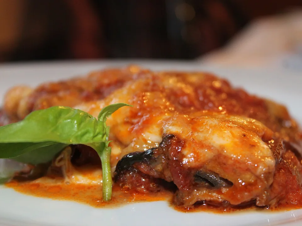 Layered eggplant parmigiana with tomato, melted cheese and basil