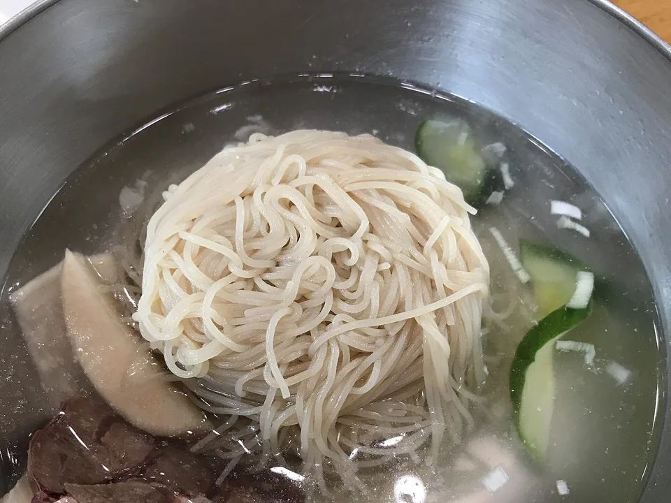 Icy mul naengmyeon with buckwheat noodles, sliced beef, cucumber, pear, radish, and hard-cooked egg