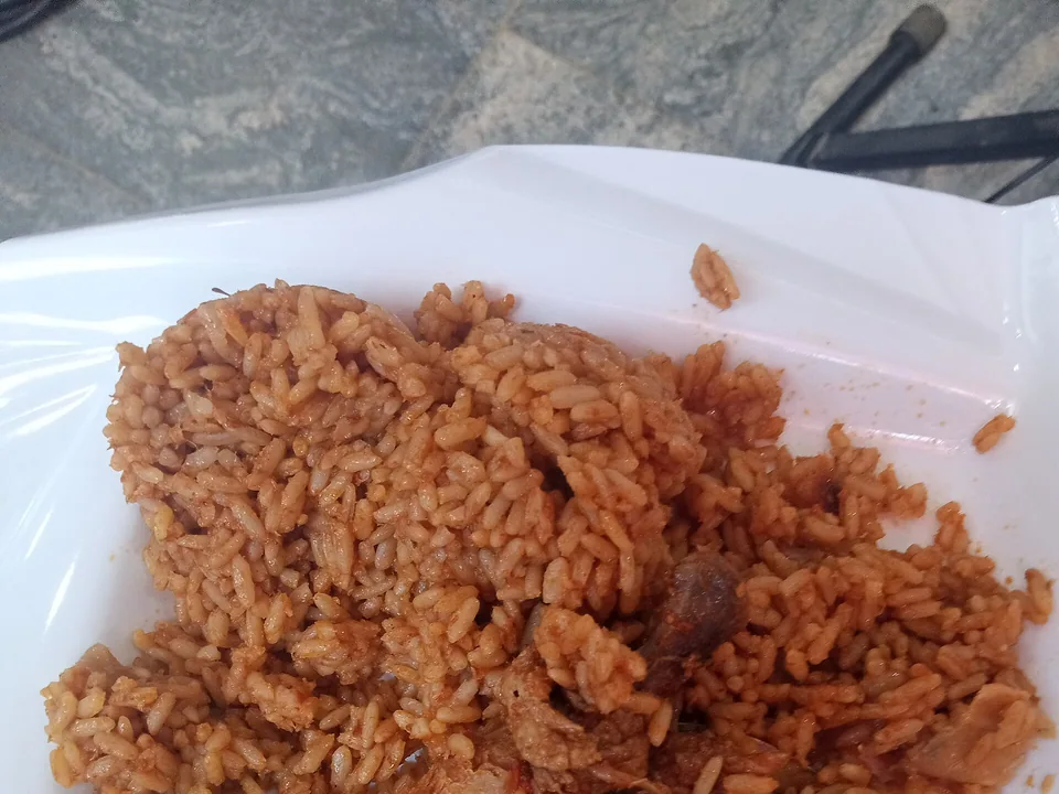 Nigerian jollof rice with separate red tomato-seasoned grains and lime