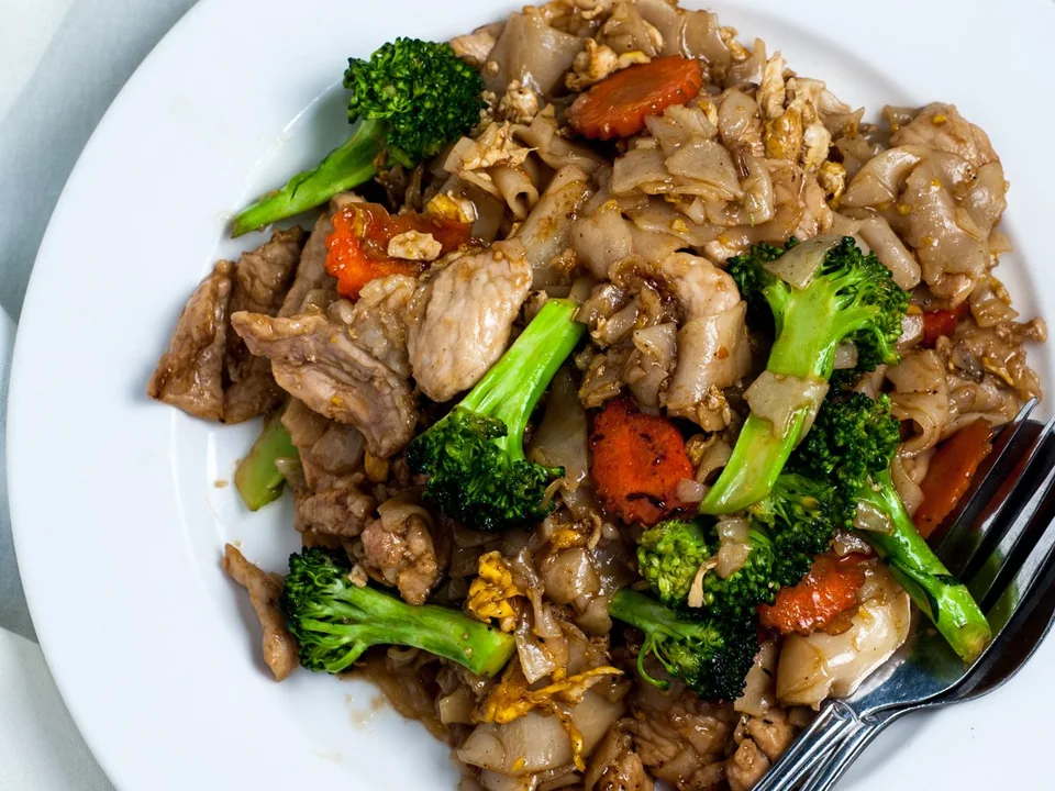 Pork Pad See Ew with wide caramelized rice noodles, Chinese broccoli, and egg