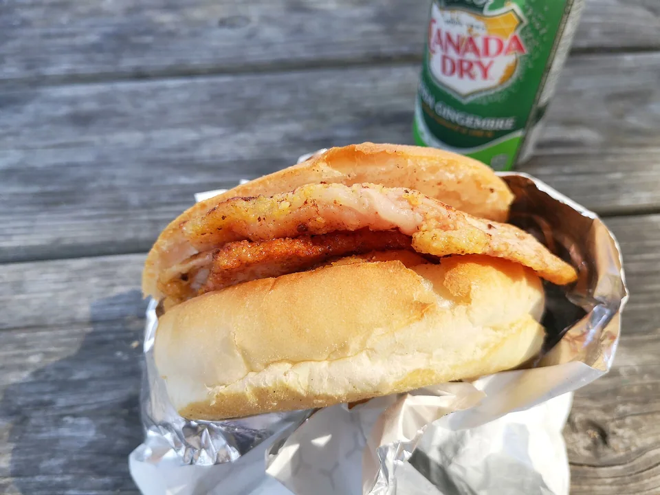 Peameal bacon stacked on a soft Toronto kaiser roll with mustard