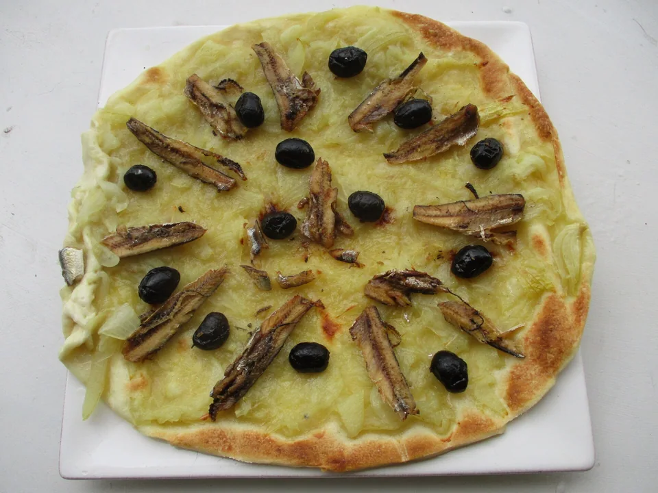 Niçoise pissaladière flatbread topped with slow-cooked onions, anchovies and black olives