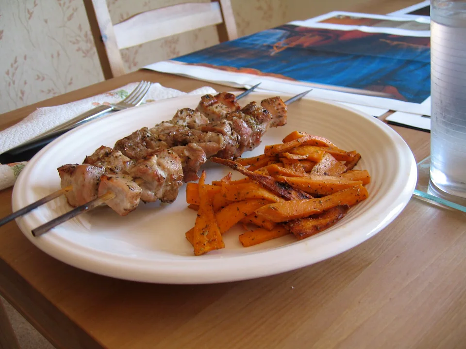 Charred Greek pork souvlaki skewers with pita, onion and tomato