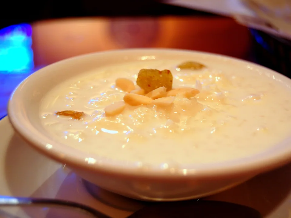 Creamy rice kheer with visible basmati grains, saffron, cardamom, almonds, pistachios, and raisins