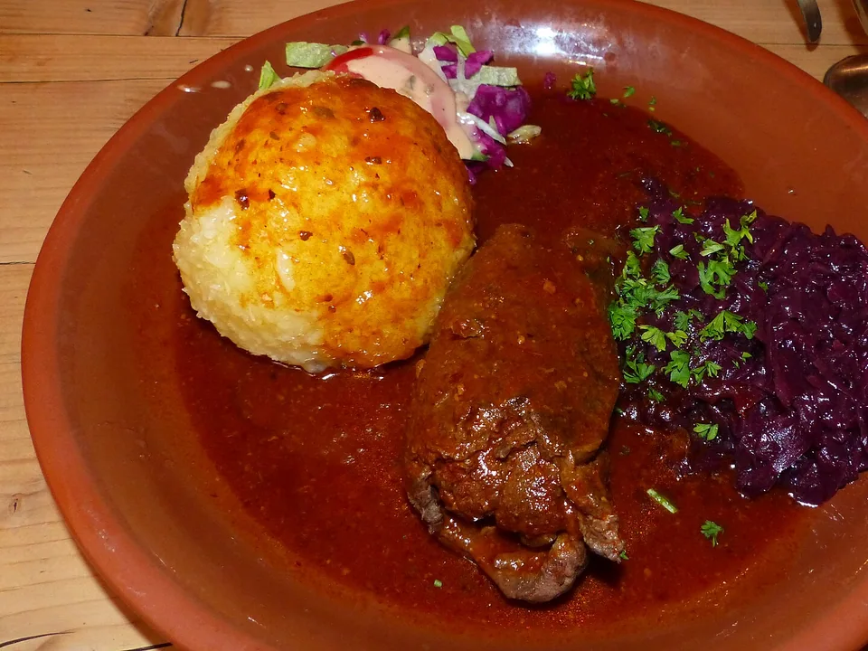 German beef roulade with dark gravy showing bacon, onion and pickle filling