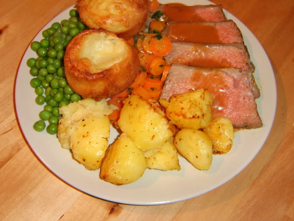 Pink sliced roast beef with Yorkshire pudding and brown gravy