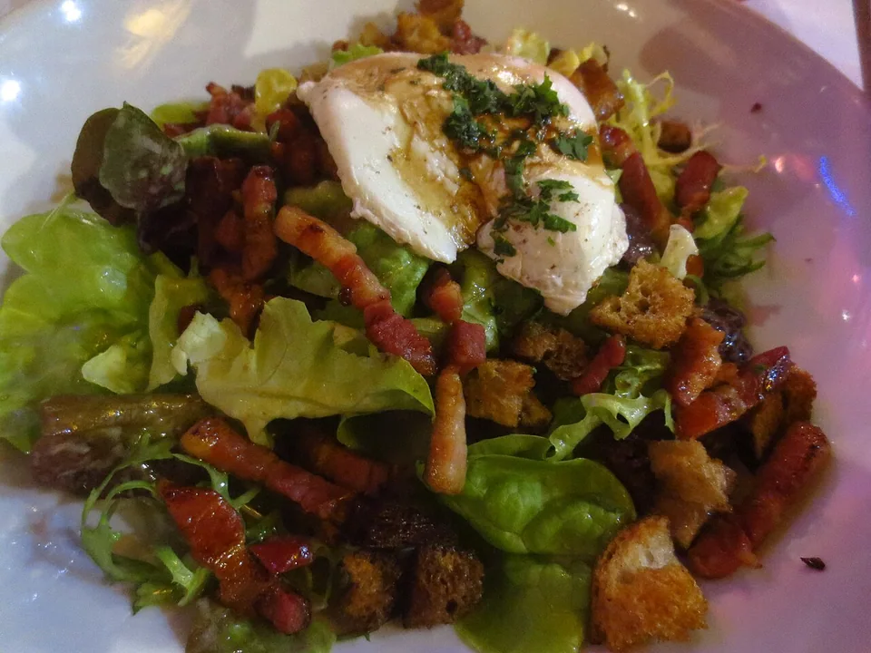 Mixed lettuce with bacon, croutons, a poached egg and parsley