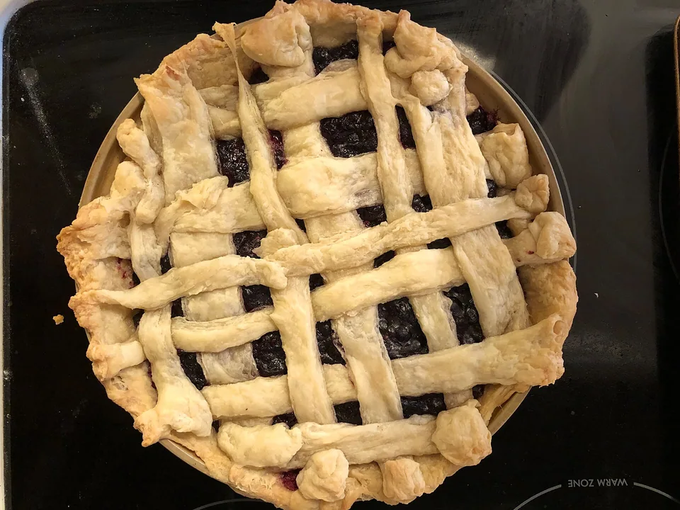 Saskatoon berry pie with deep purple filling in a golden lattice crust