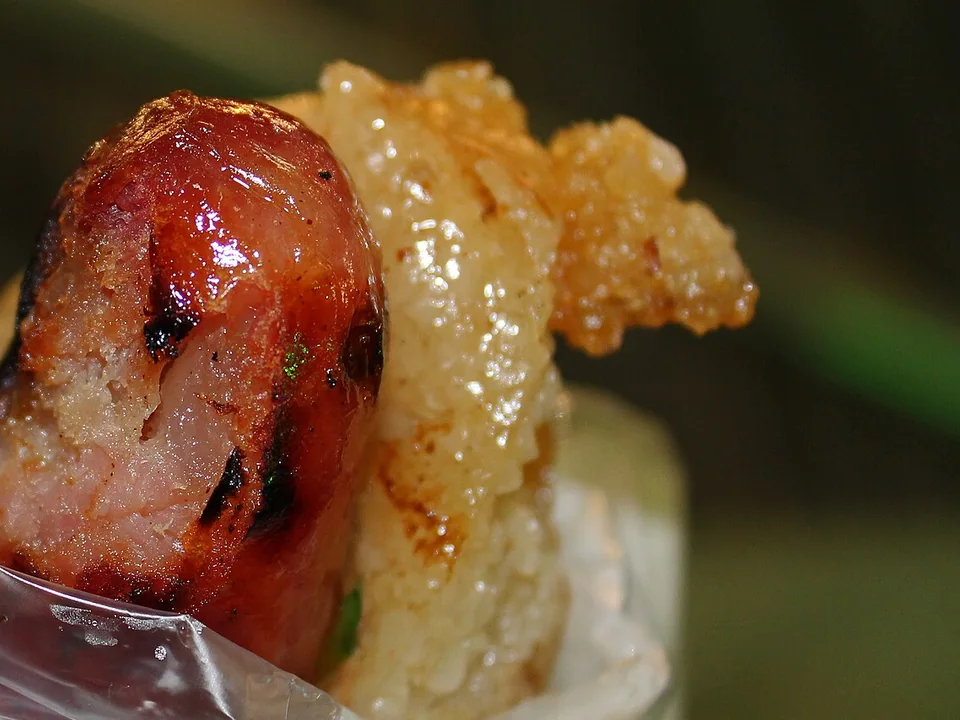 Taiwanese pork sausage inside a split grilled glutinous-rice sausage with cucumber, garlic, cilantro, and sweet chile sauce