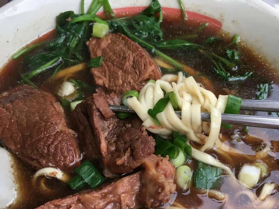 Taiwanese red-braised beef noodle soup with beef shank, bok choy, scallions, and pickled mustard greens