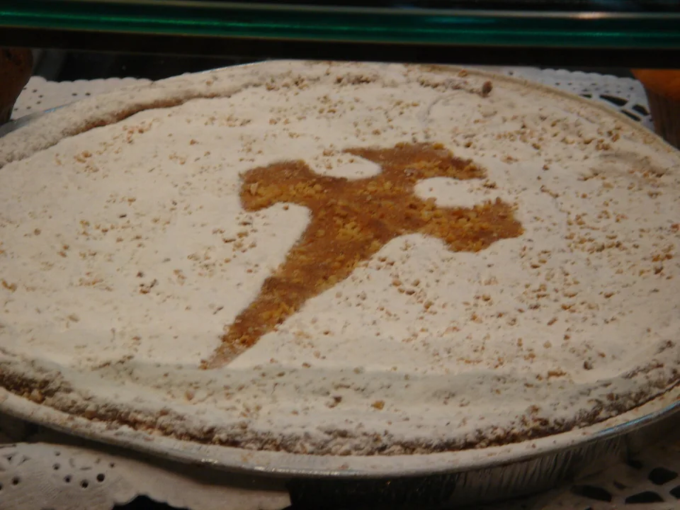 Round Tarta de Santiago with icing sugar and the Cross of Saint James