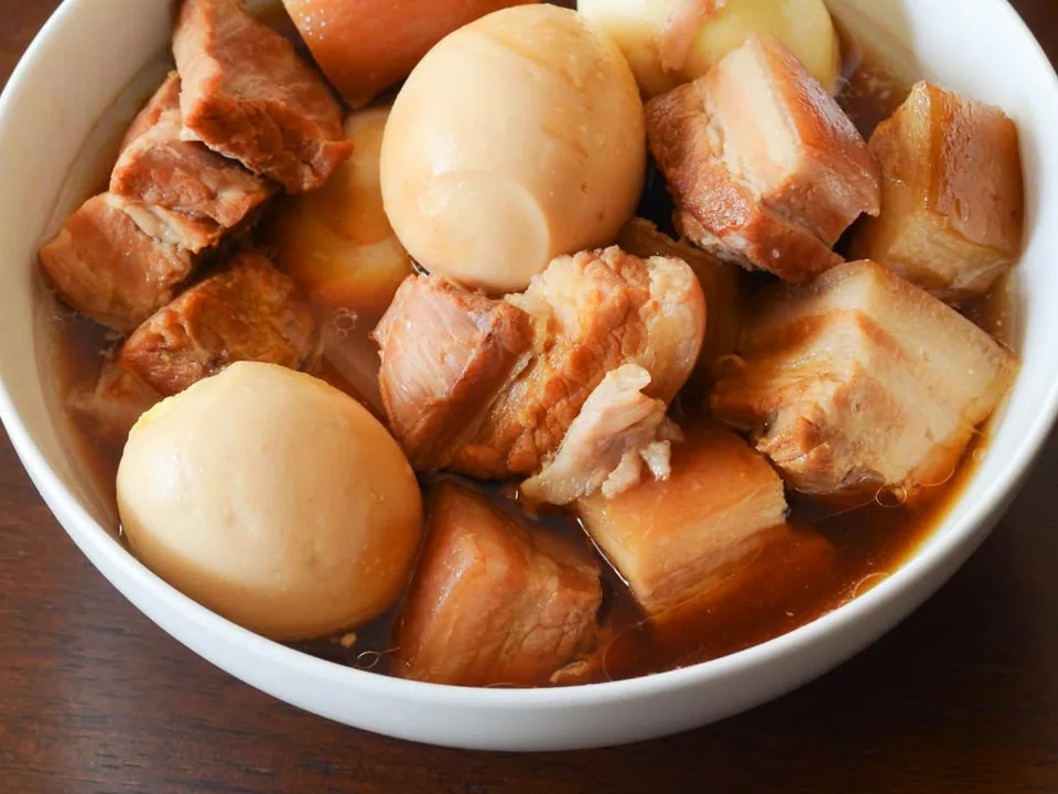Tender caramel-braised pork belly and boiled eggs in amber broth