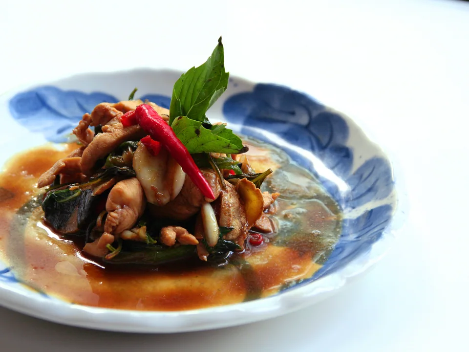 Glossy three cup chicken with ginger, whole garlic, red chile, and fresh Taiwan basil