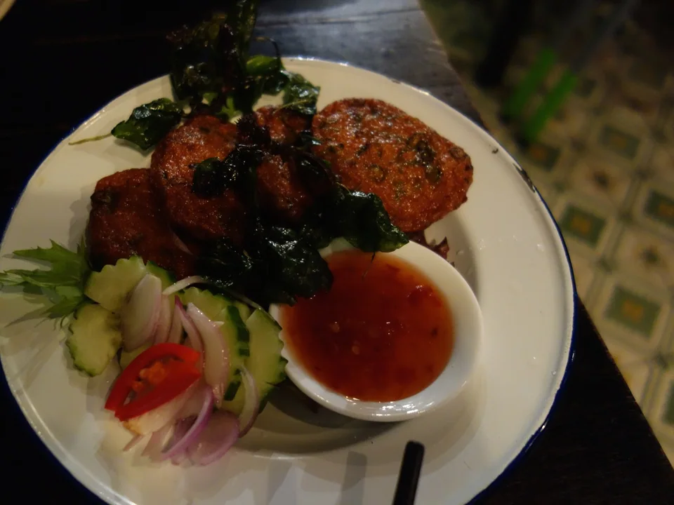 Thai fish cakes with red curry paste, long beans, lime-leaf threads, cucumber, peanuts, and sweet chile sauce
