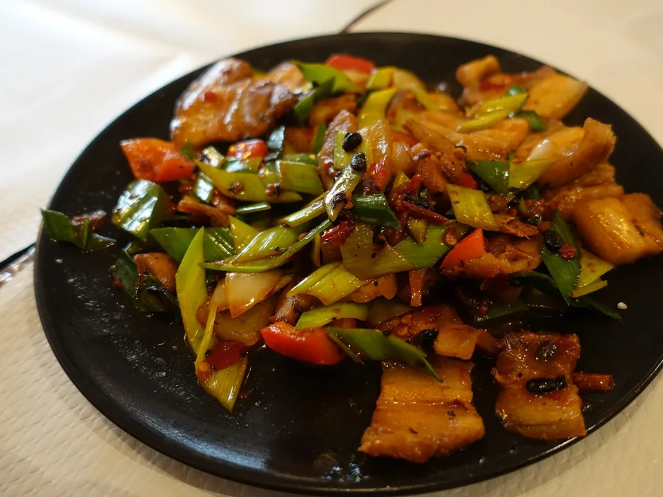 Twice-cooked pork with curled pork belly slices, green pepper, garlic chives, and red bean-paste sauce